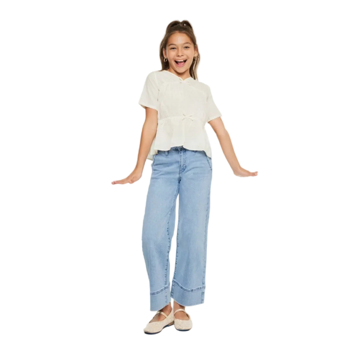 Young girl wearing a white blouse and light blue jeans on a white background
