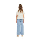 Person wearing a white top and light blue jeans on a white background